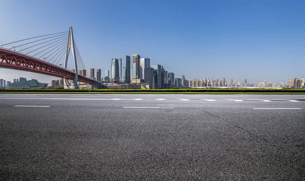 Panoramik siluet ve boş yolu, boş beton zemini olan modern iş binaları.
