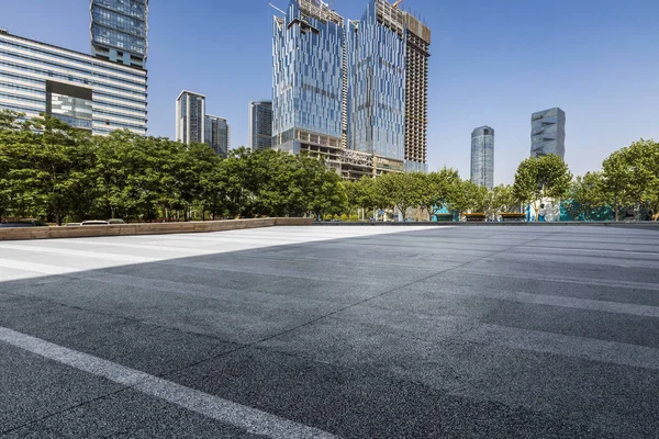 Panoramik siluet ve boş yolu, boş beton zemini olan modern iş binaları.