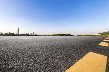 Panoramik siluet ve boş yolu, boş beton zemini olan modern iş binaları.
