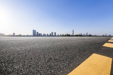 Panoramik siluet ve boş yolu, boş beton zemini olan modern iş binaları.