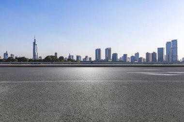 Panoramik siluet ve boş yolu, boş beton zemini olan modern iş binaları.