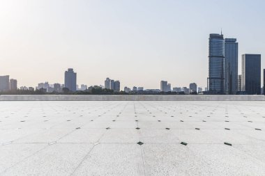 Panoramik siluet ve boş yolu, boş beton zemini olan modern iş binaları.