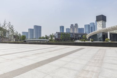 Panoramik siluet ve boş yolu, boş beton zemini olan modern iş binaları.