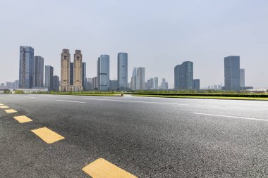 Panoramik siluet ve boş yolu, boş beton zemini olan modern iş binaları.