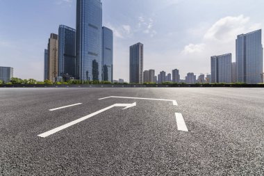 Panoramik siluet ve boş yolu, boş beton zemini olan modern iş binaları.