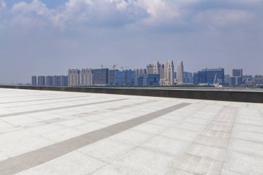 Panoramik siluet ve boş yolu, boş beton zemini olan modern iş binaları.