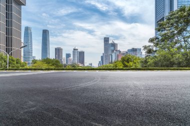 Panoramik siluet ve boş yolu, boş beton zemini olan modern iş binaları.