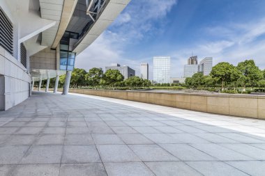 Panoramik siluet ve boş yolu, boş beton zemini olan modern iş binaları.