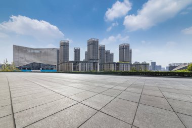 Panoramik siluet ve boş yolu, boş beton zemini olan modern iş binaları.