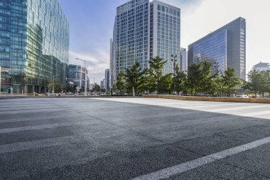 Panoramik siluet ve boş yolu, boş beton zemini olan modern iş binaları.