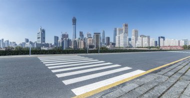 Panoramik siluet ve boş yolu, boş beton zemini olan modern iş binaları.