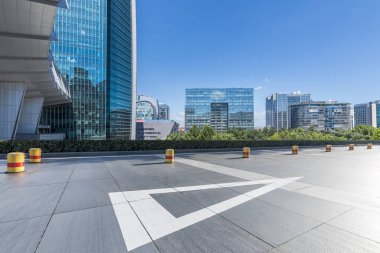 Panoramik siluet ve boş yolu, boş beton zemini olan modern iş binaları.