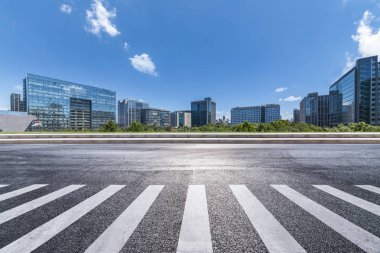 Panoramik siluet ve boş yolu, boş beton zemini olan modern iş binaları.