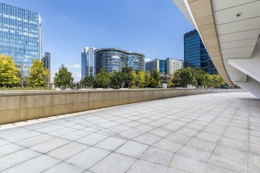 Panoramik siluet ve boş yolu, boş beton zemini olan modern iş binaları.