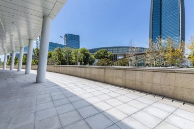 Panoramik siluet ve boş yolu, boş beton zemini olan modern iş binaları.