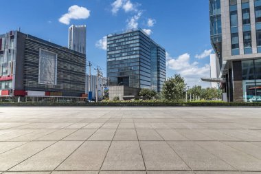 Panoramik siluet ve boş yolu, boş beton zemini olan modern iş binaları.