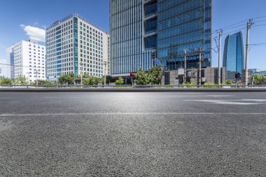 Panoramik siluet ve boş yolu, boş beton zemini olan modern iş binaları.