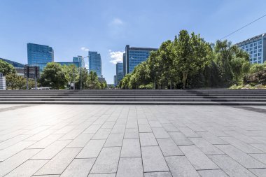 Panoramik siluet ve boş yolu, boş beton zemini olan modern iş binaları.