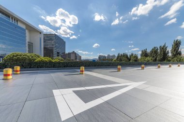 Panoramik siluet ve boş yolu, boş beton zemini olan modern iş binaları.