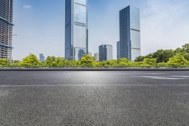 Panoramik siluet ve boş yolu, boş beton zemini olan modern iş binaları.