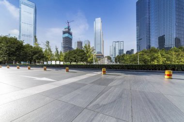 Panoramik siluet ve boş yolu, boş beton zemini olan modern iş binaları.