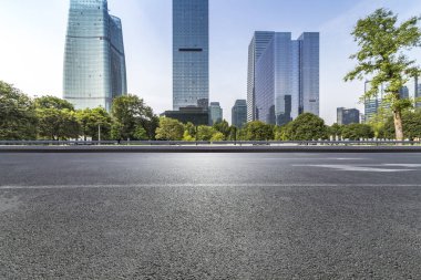 Panoramik siluet ve boş yolu, boş beton zemini olan modern iş binaları.