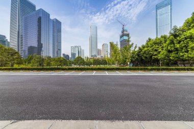 Panoramik siluet ve boş yolu, boş beton zemini olan modern iş binaları.