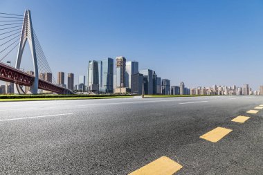Panoramik siluet ve boş yolu, boş beton zemini olan modern iş binaları.