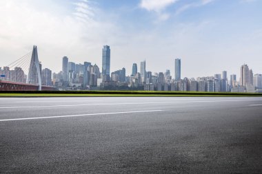 Panoramik siluet ve boş yolu, boş beton zemini olan modern iş binaları.