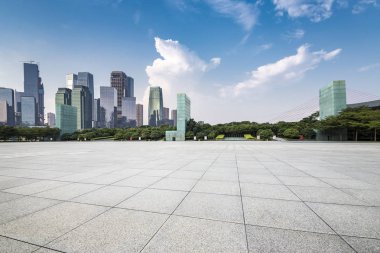 Panoramik siluet ve boş yolu, boş beton zemini olan modern iş binaları.