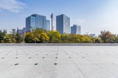 Panoramik siluet ve boş yolu, boş beton zemini olan modern iş binaları.