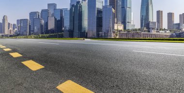 Panoramik siluet ve boş yolu, boş beton zemini olan modern iş binaları.