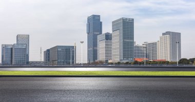 Panoramik siluet ve boş yolu, boş beton zemini olan modern iş binaları.