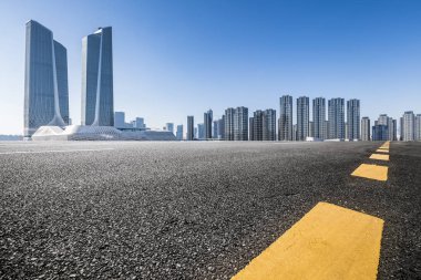Panoramik siluet ve boş yolu, boş beton zemini olan modern iş binaları.