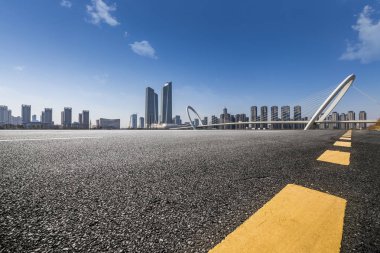 Panoramik siluet ve boş yolu, boş beton zemini olan modern iş binaları.