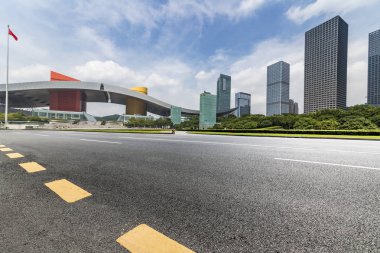 Panoramik siluet ve boş yolu, boş beton zemini olan modern iş binaları.