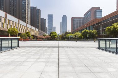 Panoramik siluet ve boş yolu, boş beton zemini olan modern iş binaları.