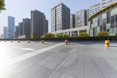 Panoramik siluet ve boş yolu, boş beton zemini olan modern iş binaları.