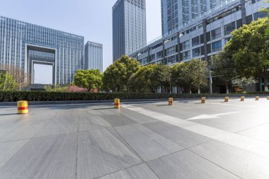 Panoramik siluet ve boş yolu, boş beton zemini olan modern iş binaları.