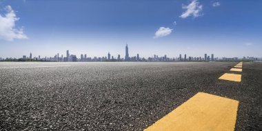 Panoramik siluet ve boş yolu, boş beton zemini olan modern iş binaları.