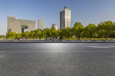 Panoramik siluet ve boş yolu, boş beton zemini olan modern iş binaları.