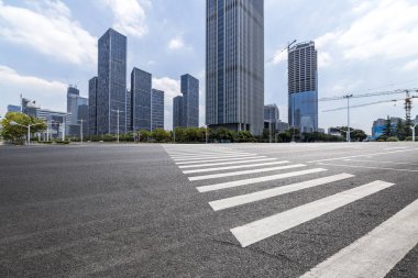 Panoramik siluet ve boş yolu, boş beton zemini olan modern iş binaları.