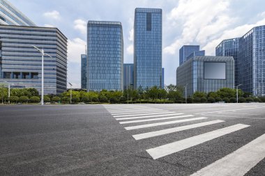 Panoramik siluet ve boş yolu, boş beton zemini olan modern iş binaları.