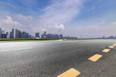 Panoramik siluet ve boş yolu, boş beton zemini olan modern iş binaları.