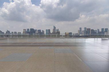 Panoramik siluet ve boş yolu, boş beton zemini olan modern iş binaları.