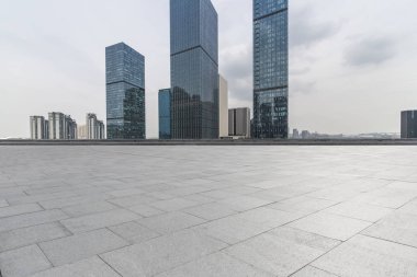 Panoramik siluet ve boş yolu, boş beton zemini olan modern iş binaları.
