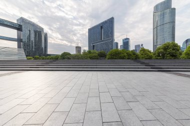 Panoramik siluet ve boş yolu, boş beton zemini olan modern iş binaları.