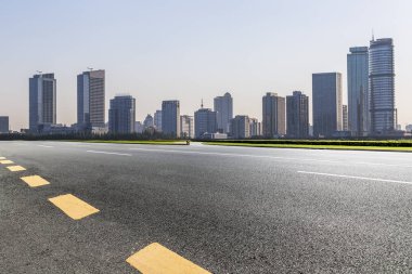 Panoramik siluet ve boş yolu, boş beton zemini olan modern iş binaları.