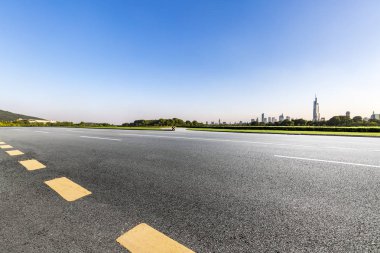 Panoramik siluet ve boş yolu, boş beton zemini olan modern iş binaları.