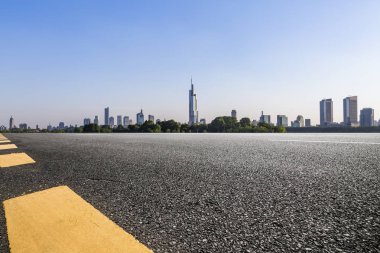 Panoramik siluet ve boş yolu, boş beton zemini olan modern iş binaları.
